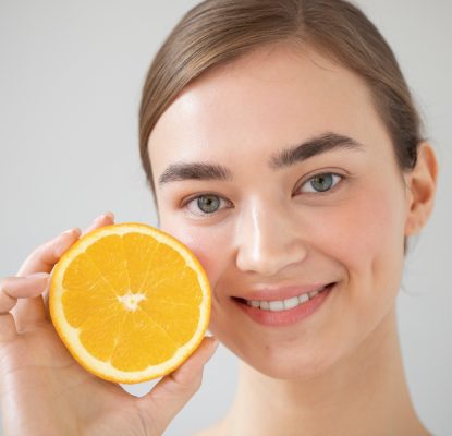 portrait-beautiful-woman-with-clear-skin-holding-sliced-orange-fruit
