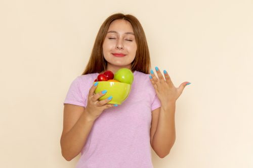 front-view-young-female-pink-t-shirt-blue-jeans-holding-plate-with-fruits