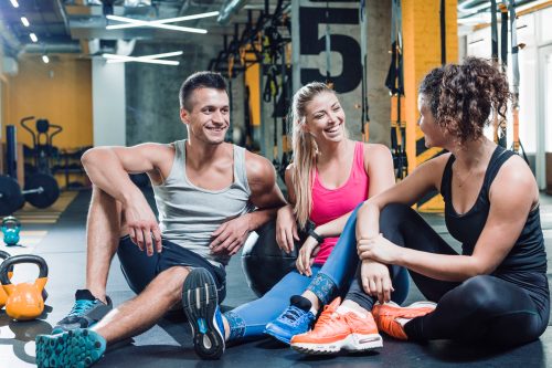 group-happy-people-sitting-floor-after-workout