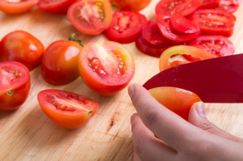 person-cutting-sliced-tomatoes