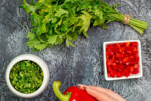 top-view-fresh-greens-with-red-bell-peppers-light-grey-table