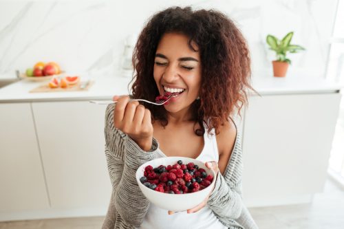 young-woman-eating-healthy-food-kitchen